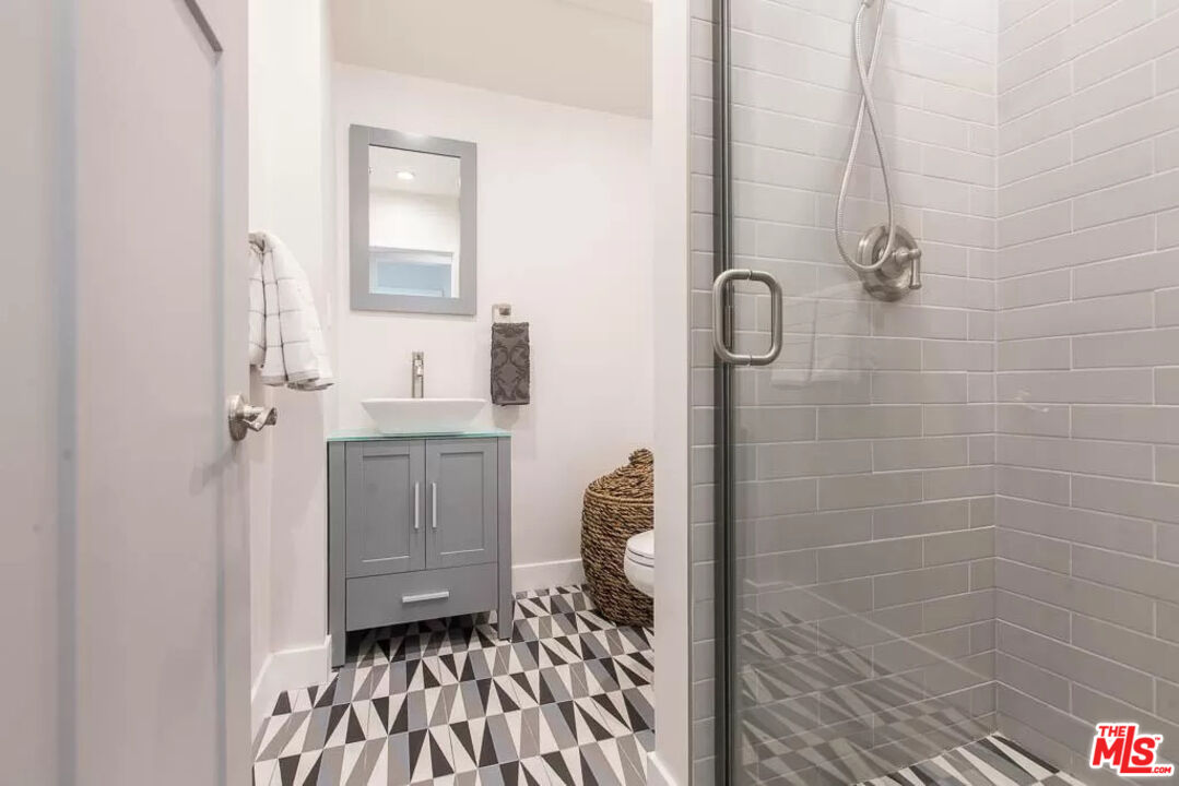 2419 Walnut Avenue Venice, CA 90291 - Photo 9 of 16 a bathroom with a granite countertop sink a toilet and a mirror