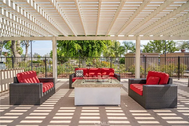 a view of swimming pool with outdoor seating and trees in the background