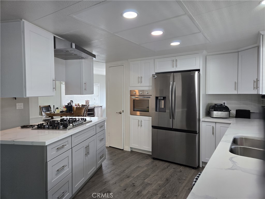 1001 West Lambert Road, Unit 153 La Habra, CA 90631 - Photo 2 of 24 a kitchen with a refrigerator sink and white cabinets