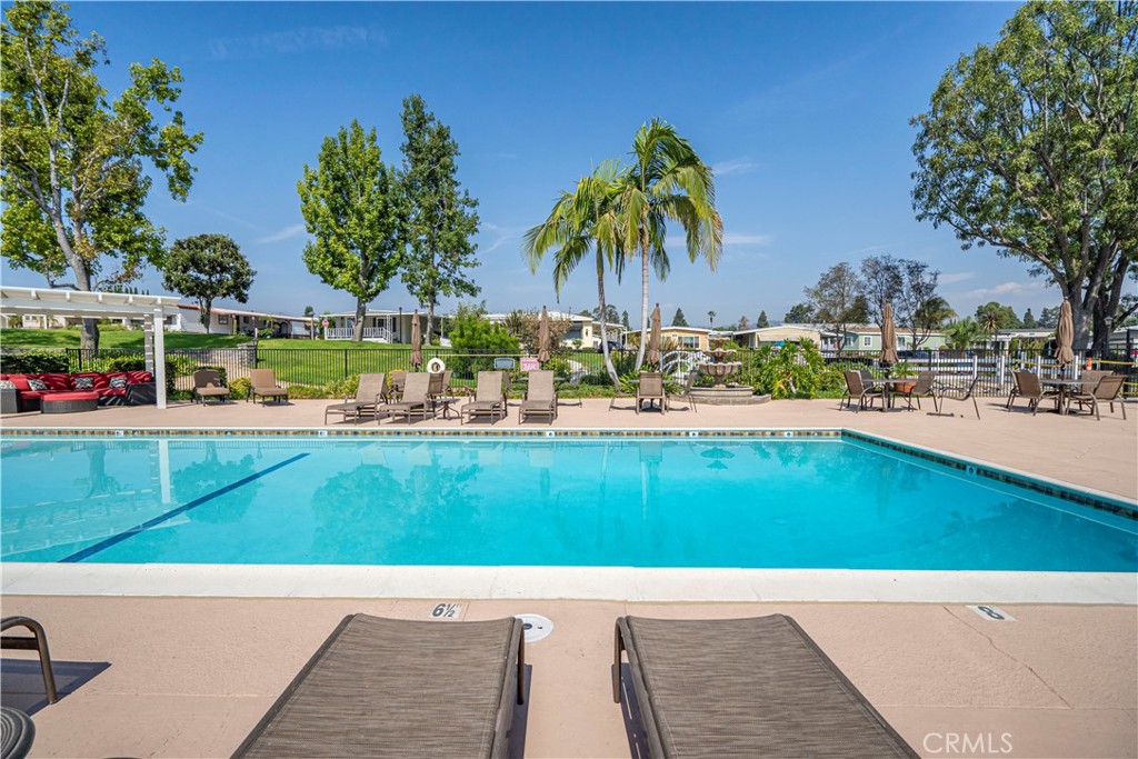 1001 West Lambert Road, Unit 153 La Habra, CA 90631 - Photo 21 of 24 a view of swimming pool with outdoor seating and trees in the background