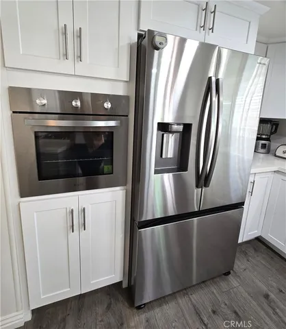 a metallic refrigerator freezer sitting in a kitchen