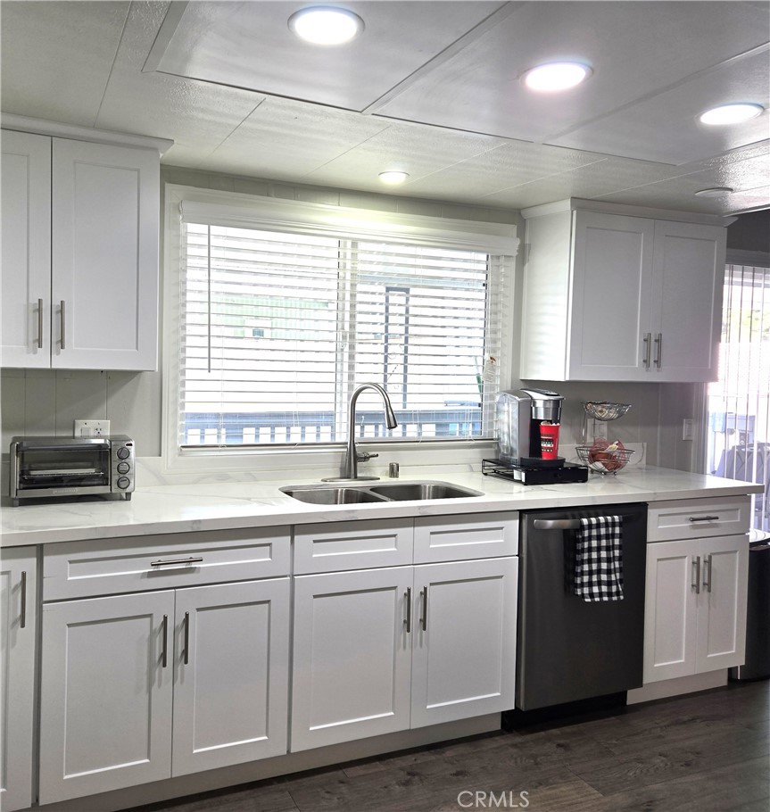 1001 West Lambert Road, Unit 153 La Habra, CA 90631 - Photo 4 of 28 a kitchen with white cabinets appliances a sink and a window