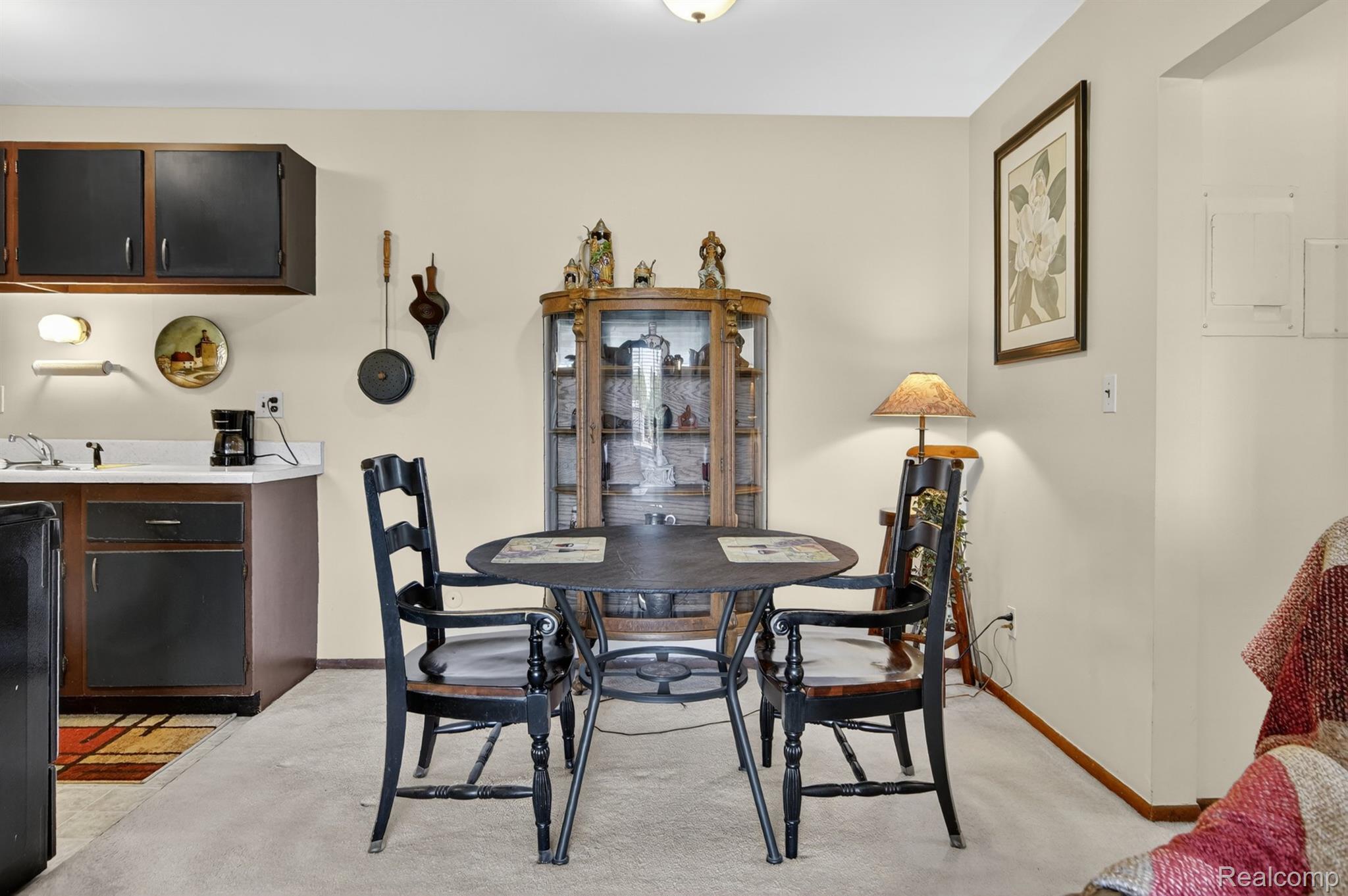 24111 Meridian Road, Unit 116 Grosse Ile, MI 48138 - Photo 11 of 26 Compact dining area featuring a round table and two dark-toned chairs