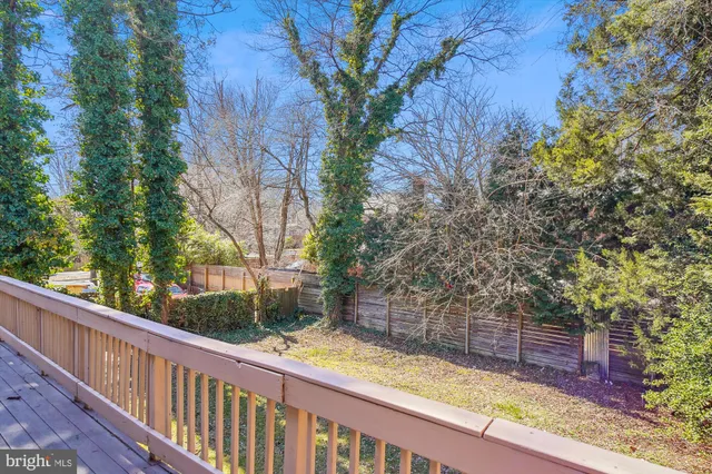 a view of a house with a big yard plants and large tree