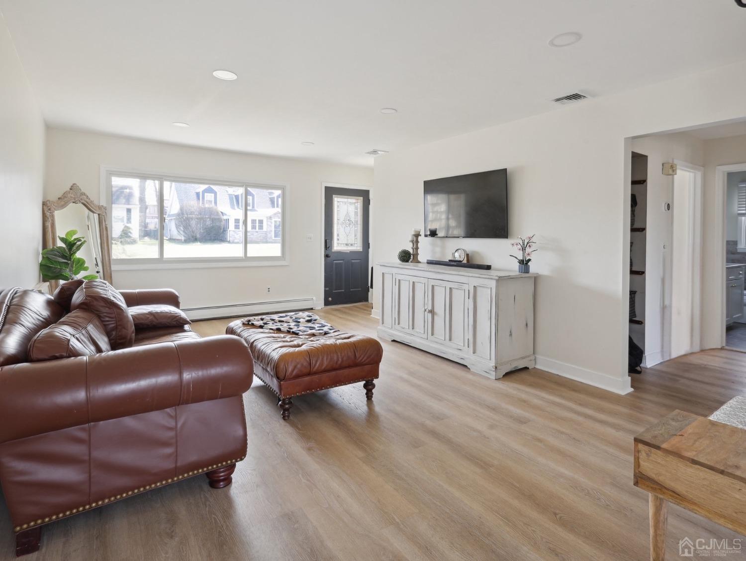 82 Normandy Road Colonia, NJ 07067 - Photo 6 of 33 a living room with furniture a flat screen tv and a wooden floor