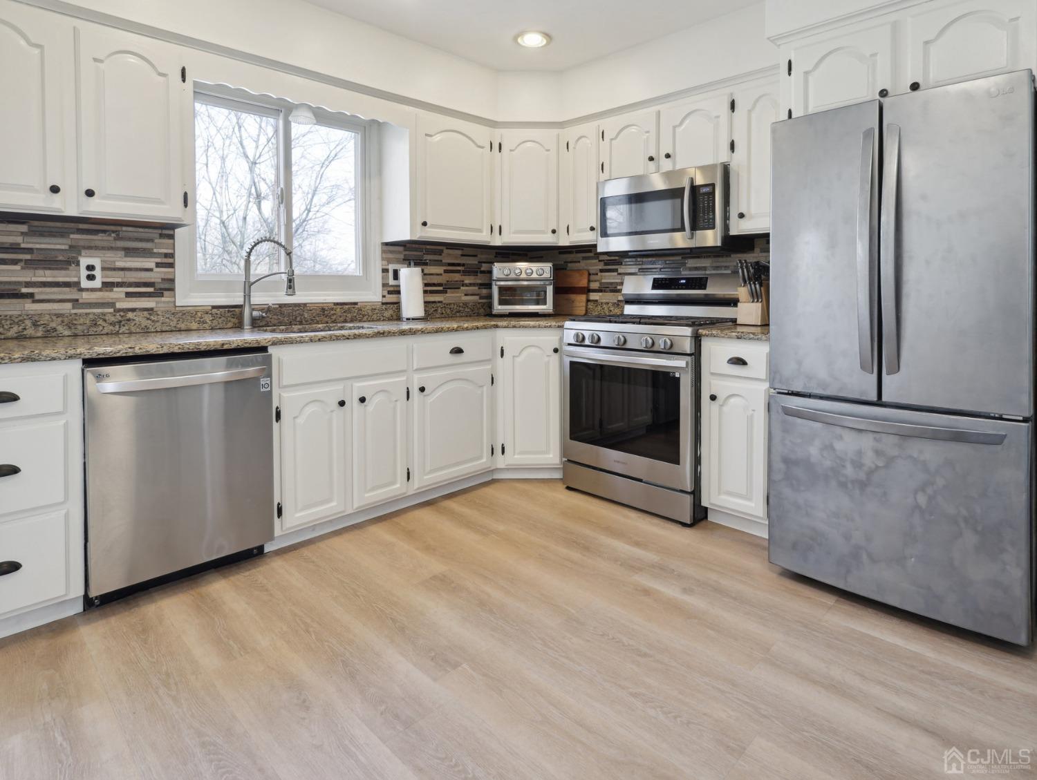 82 Normandy Road Colonia, NJ 07067 - Photo 10 of 33 a kitchen with stainless steel appliances granite countertop a stove a sink and a refrigerator