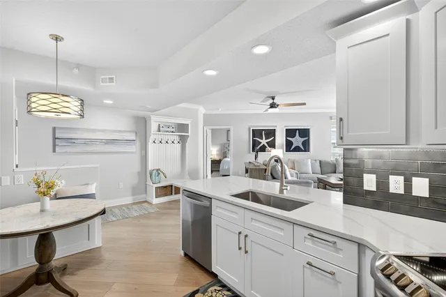 a very nice looking kitchen with granite countertop a stove a sink a dining table and chairs