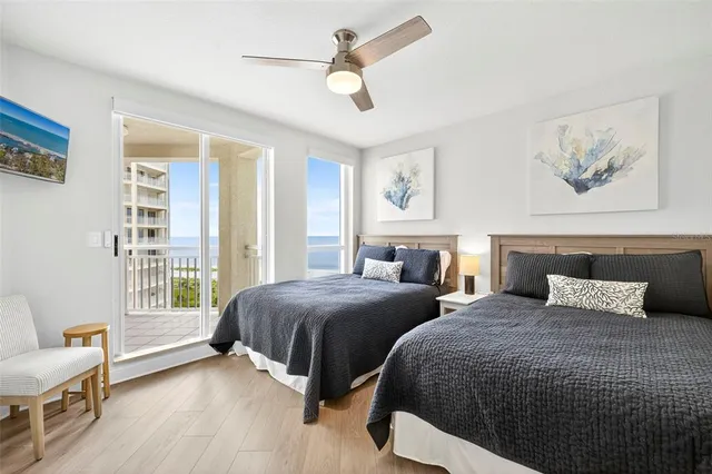 a bedroom with two beds and a large window