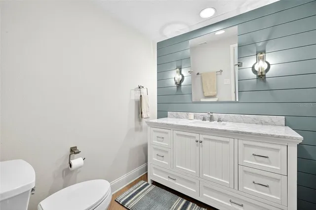 a bathroom with a granite countertop toilet sink and mirror