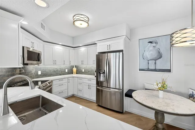 a kitchen with a sink appliances and cabinets