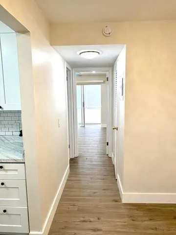 a view of a hallway with wooden floor