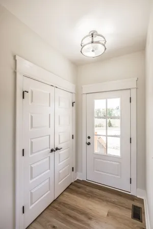 a kitchen with stainless steel appliances granite countertop a refrigerator a sink a stove and white cabinets