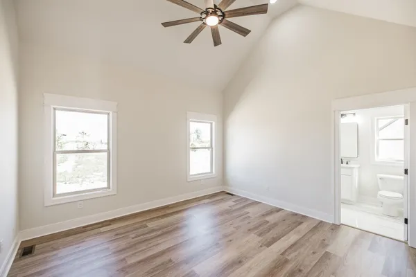 a view of a big room with wooden floor and windows