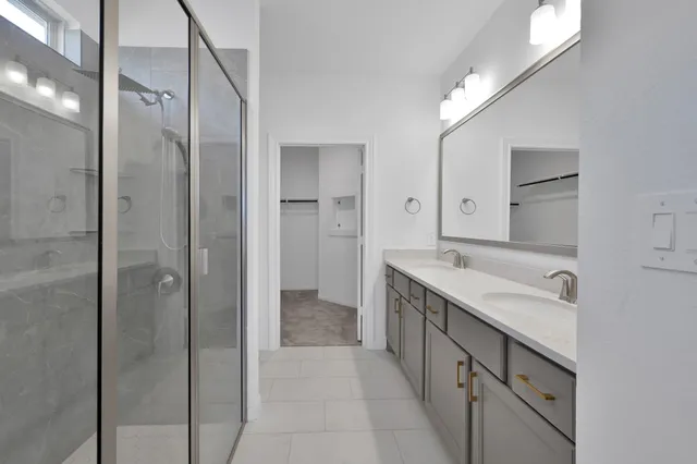a spacious bathroom with a shower sink and mirror