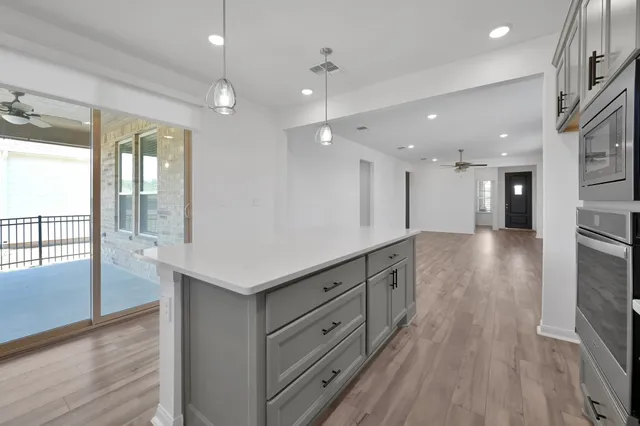 a large kitchen with kitchen island a large counter top space a sink stainless steel appliances and windows