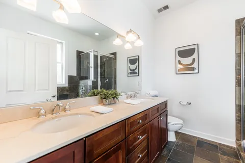 a bathroom with a sink double vanity and a toilet