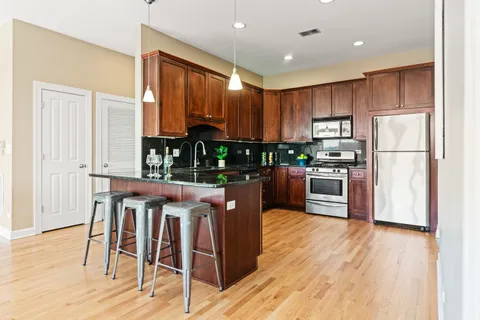 a kitchen with stainless steel appliances wooden floors and wooden cabinets
