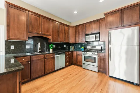 a kitchen with stainless steel appliances granite countertop a refrigerator sink and cabinets