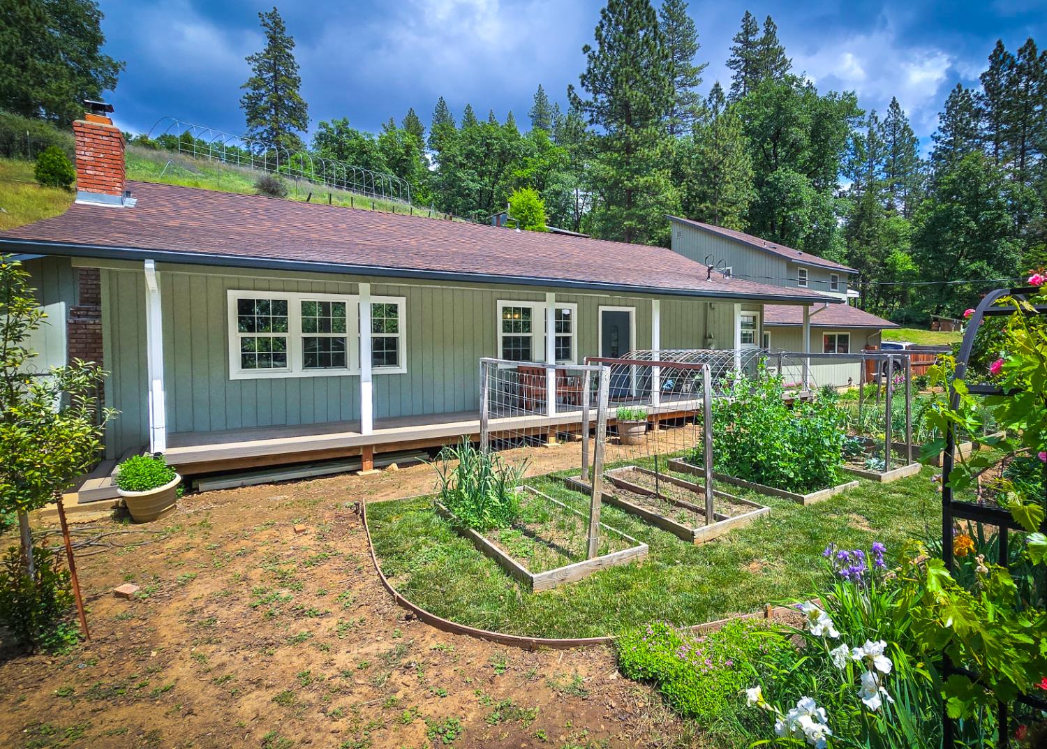 Beautiful, fenced front yard with gorgeous flowers and raised garden beds.