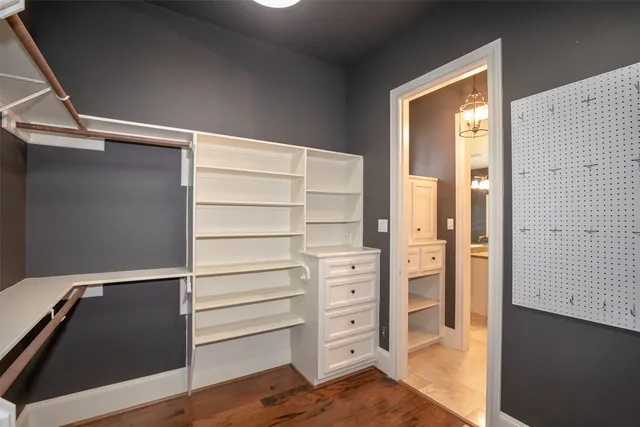 an empty room with wooden floor a ceiling fan and windows