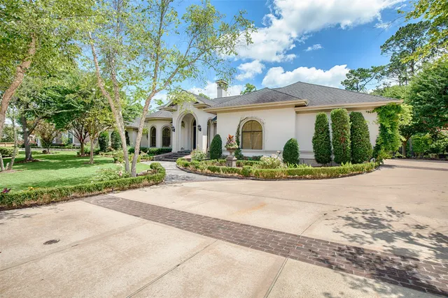 a front view of a house with a yard and potted plants