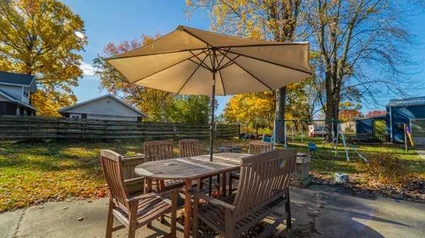 a view of a patio with a table chairs and a swimming pool