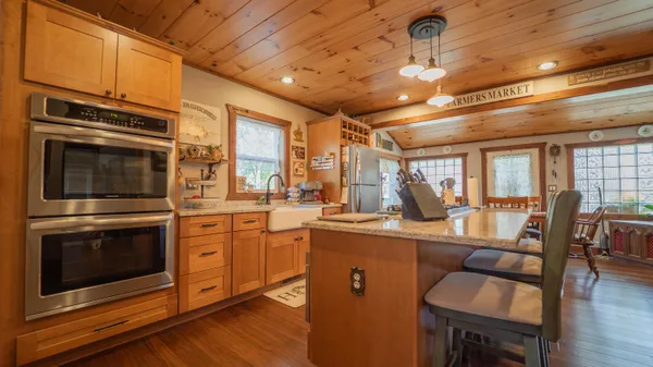 a kitchen with stainless steel appliances granite countertop a sink a stove and cabinets