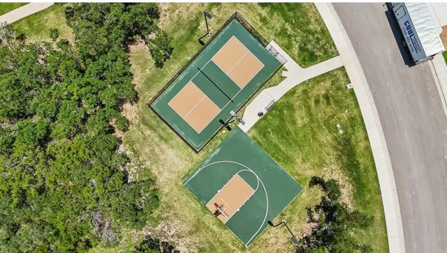 an aerial view of a house with a yard and street