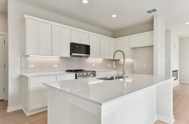 a kitchen with stainless steel appliances granite countertop a sink a stove and a refrigerator