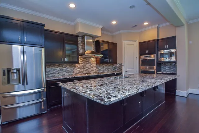 a kitchen with stainless steel appliances granite countertop a table and refrigerator