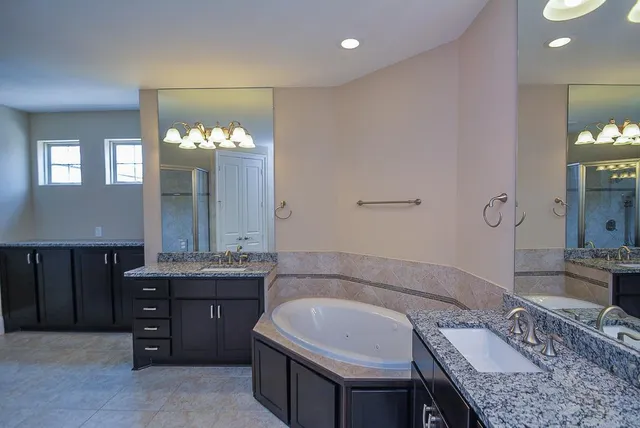 a spacious bathroom with a granite countertop sink and a mirror