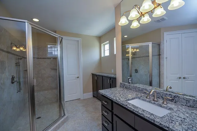 a bathroom with a granite countertop sink a light fixture and a mirror