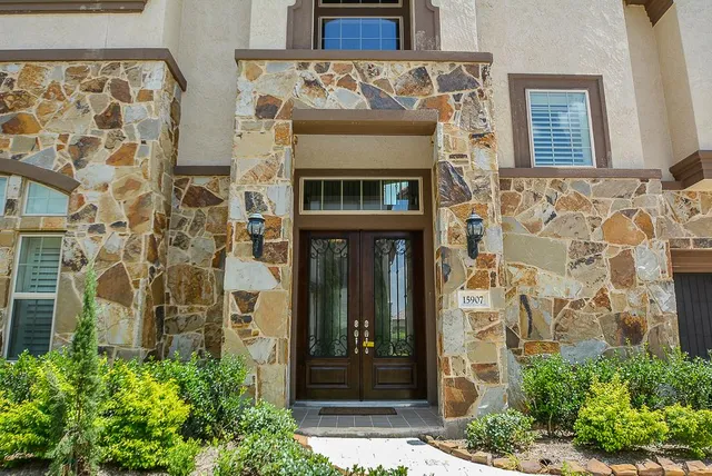 front door with brick wall and windows
