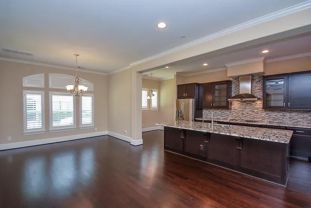 an open kitchen with wooden floor and large window