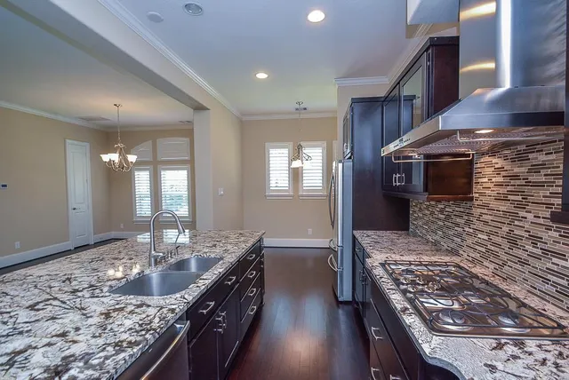 a kitchen with stainless steel appliances granite countertop a sink stove and cabinets
