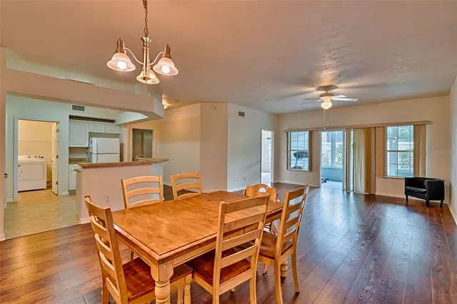 a dining room with wooden floor and chandelier