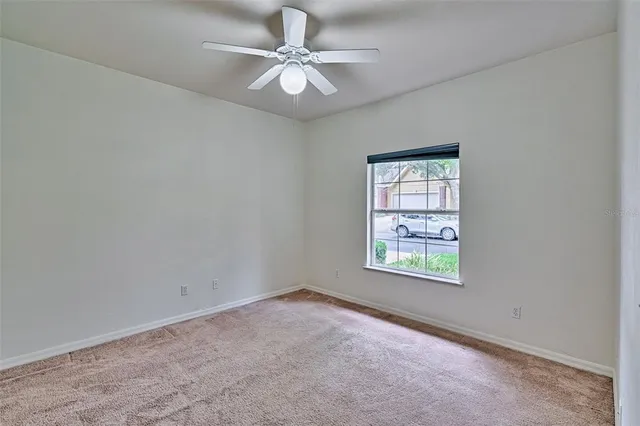 an empty room with a window and a fan