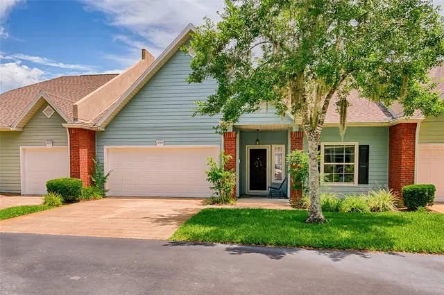 a front view of a house with a garden and plants