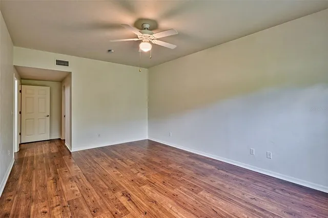 a view of an empty room with wooden floor