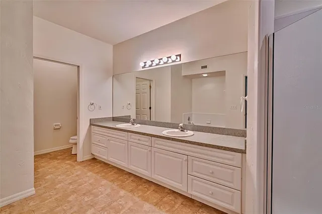 a spacious bathroom with a granite countertop sink a mirror and a