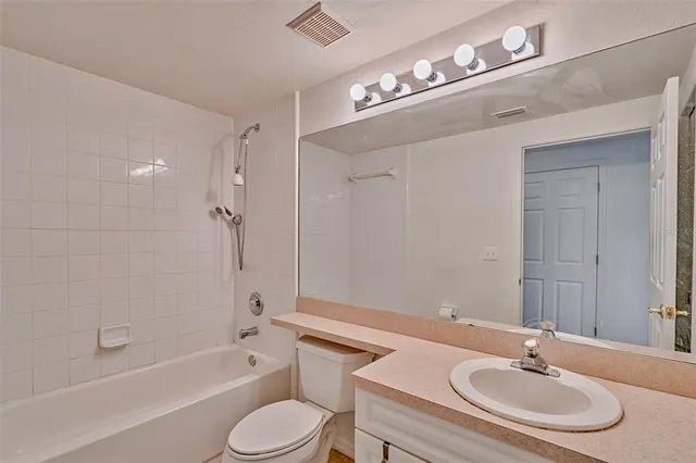 a bathroom with a granite countertop sink toilet a mirror and shower