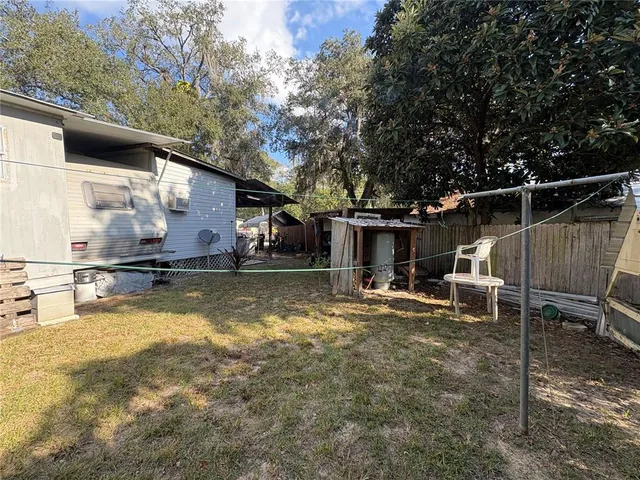 a view of a house with pool chairs and a yard