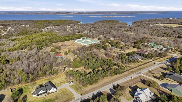 an aerial view of a city with lots of residential buildings and ocean view in back