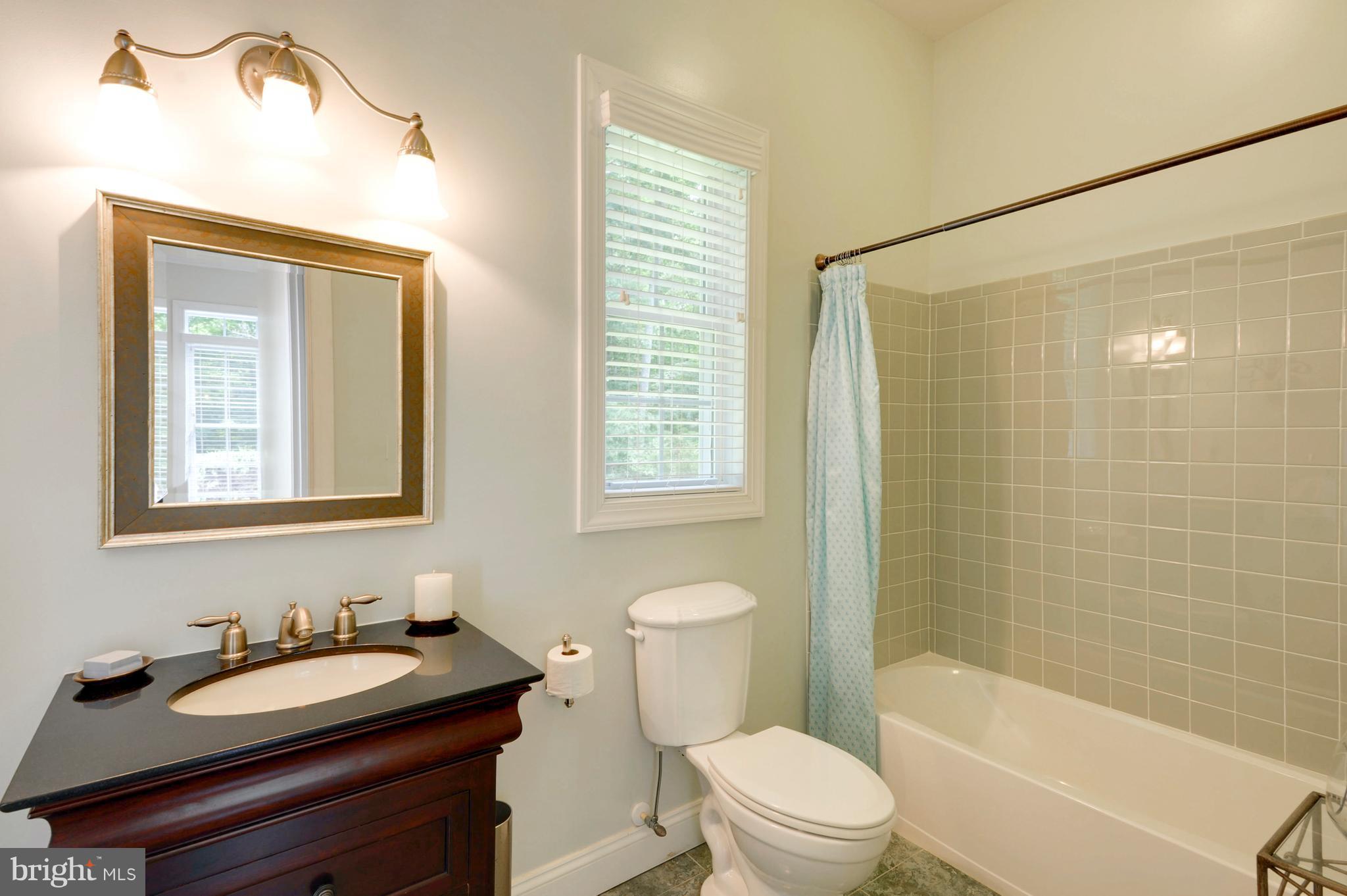 9440 Billingsley Road White Plains, MD 20695 - Photo 21 of 30 a bathroom with a granite countertop sink toilet a mirror and shower