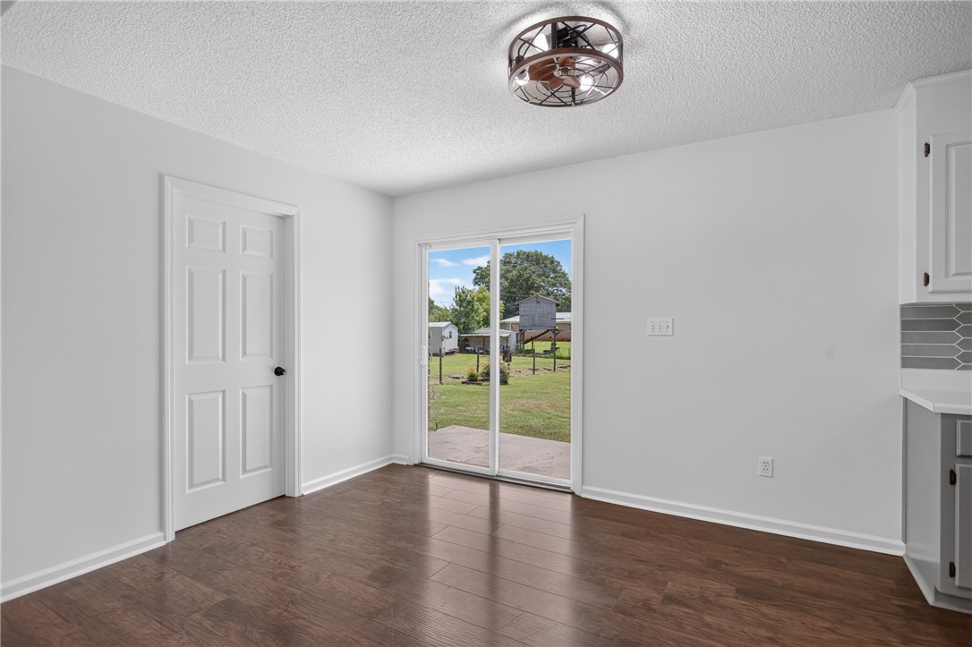 113 Greenfield Avenue Pendleton, SC 29670 - Photo 12 of 40 Rich hardwood floors complement a modern ceiling fan, creating a welcoming atmosphere.
