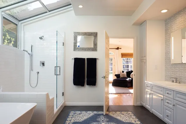 a bathroom with a tub a double vanity sink and mirror