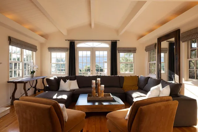 a living room with furniture and large windows