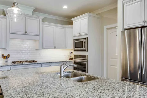 a kitchen with white cabinets and a stove