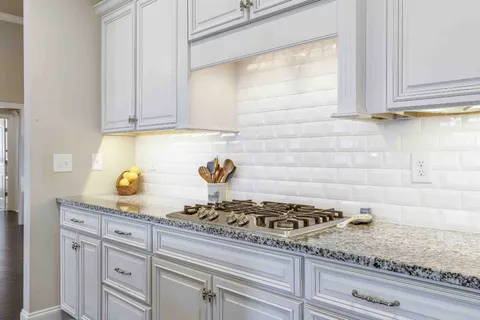 a kitchen with a stove a counter space a sink and dishwasher