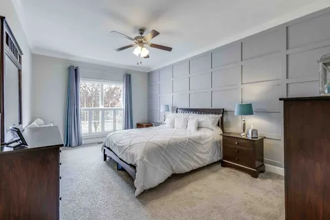 a bedroom with a bed and a flat tv screen on dresser